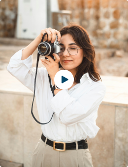 Person taking a photo with a vintage camera outdoors.