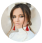 A woman with red earrings and a white outfit.