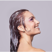 Profile of a smiling woman with wet hair and colorful makeup.