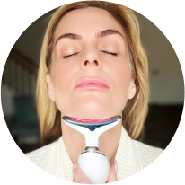 Woman using a skincare device on her chin and neck.