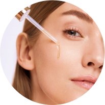 Close-up of a person applying facial serum with a dropper.