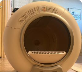 A spherical automatic cat litter box with an open entry and control panel.