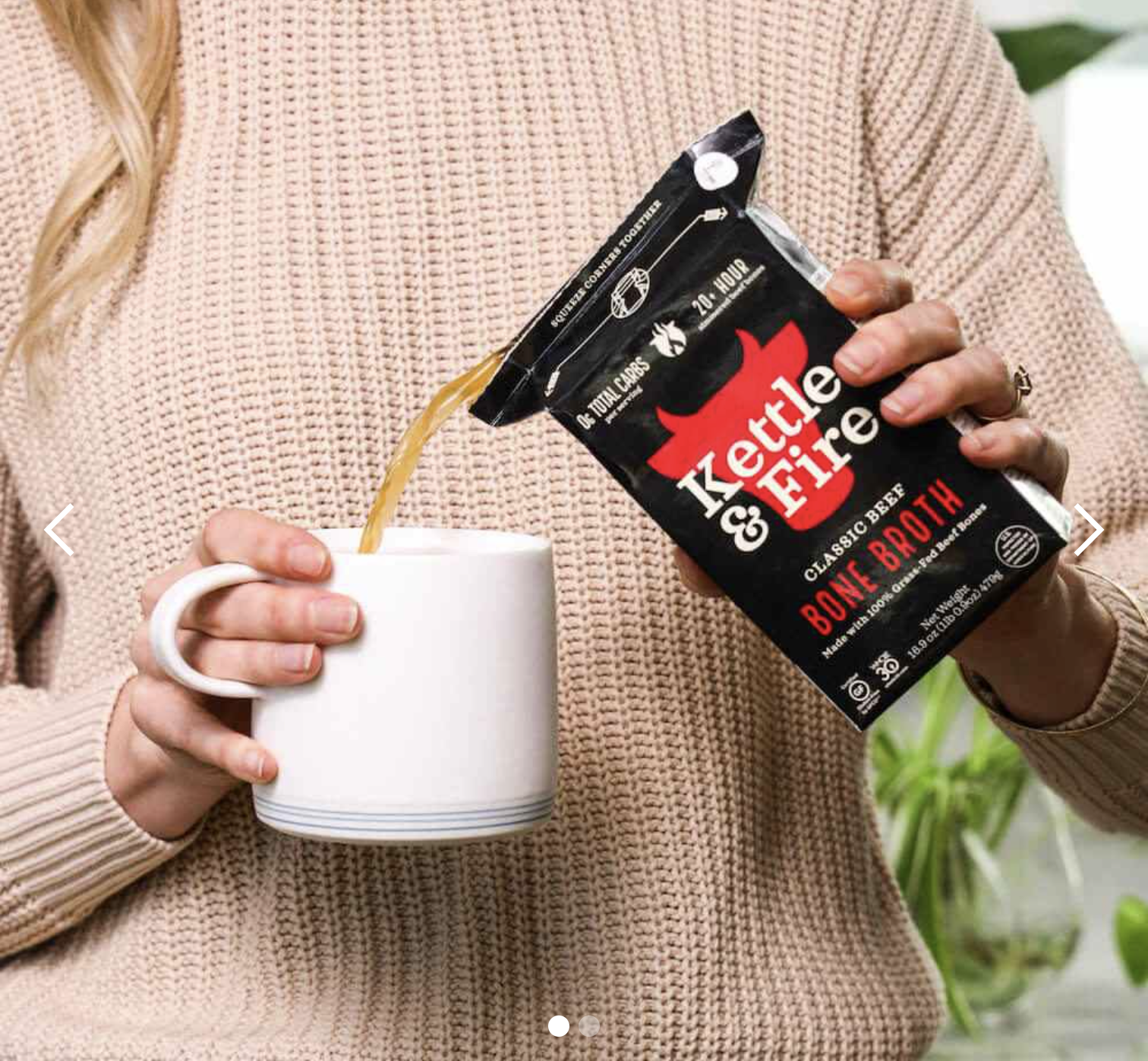 Person pouring bone broth from a carton into a white mug.