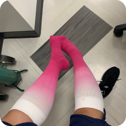 Customer wearing pink ombre Comrad compression socks on a clinic floor