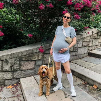Pregnant woman walking dog with Comrad compression socks on