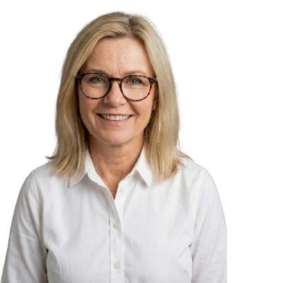 A smiling woman with blonde hair and glasses wearing a white button-down shirt against a black background.