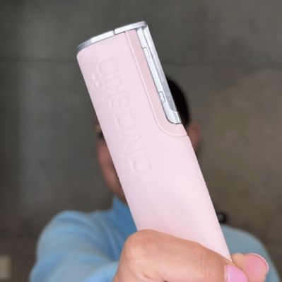 Person holding a pink Alvaskin device close to the camera.