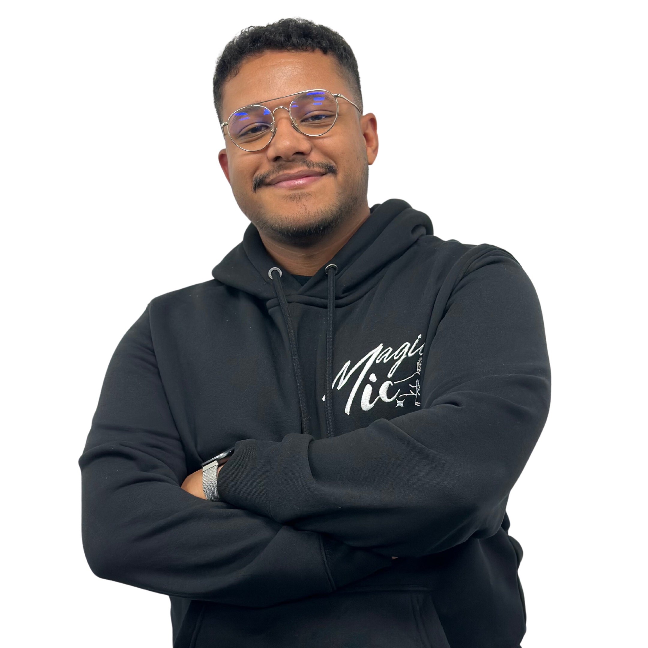 Person in a black hoodie with arms crossed, smiling.