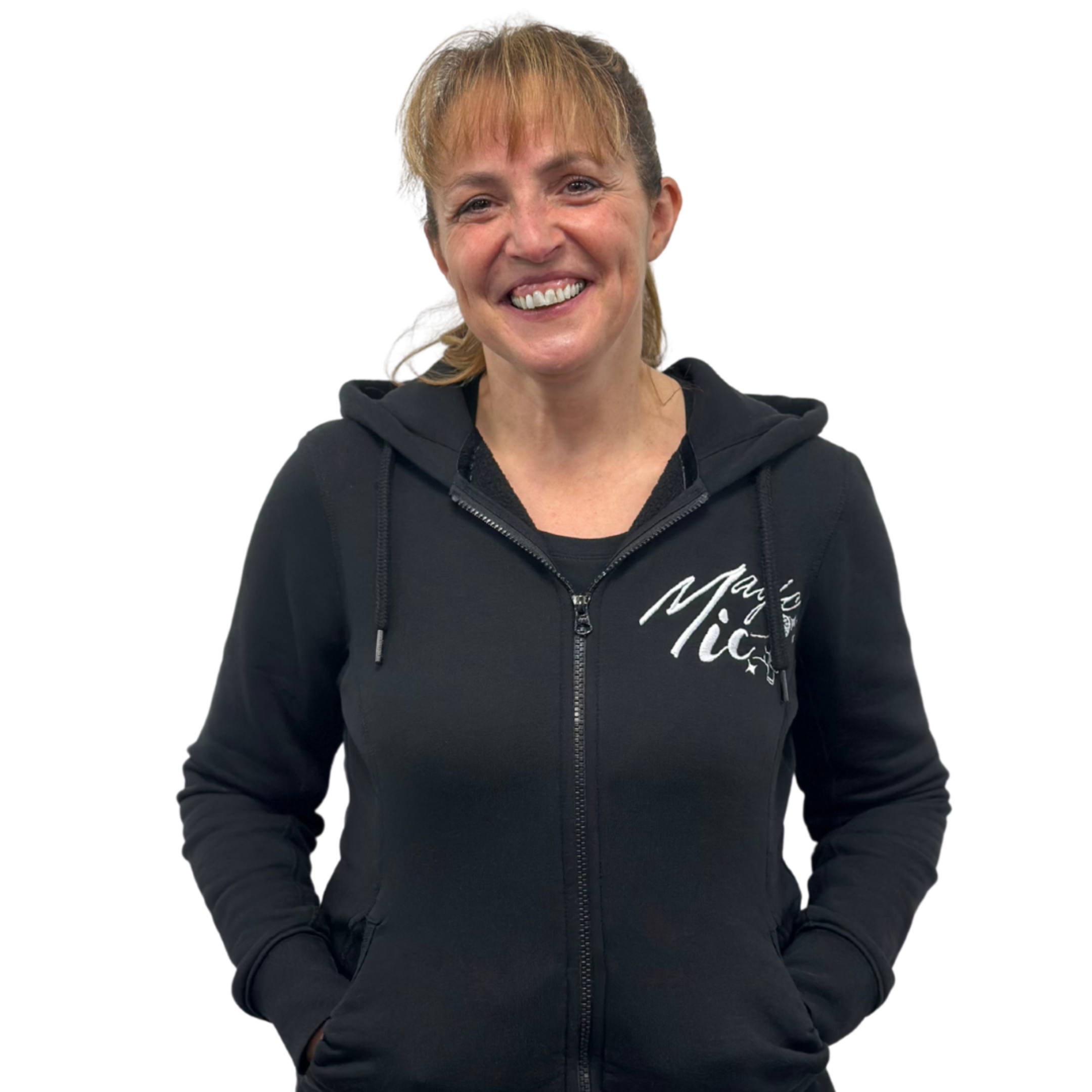 Smiling person in a black hoodie with hands in pockets.