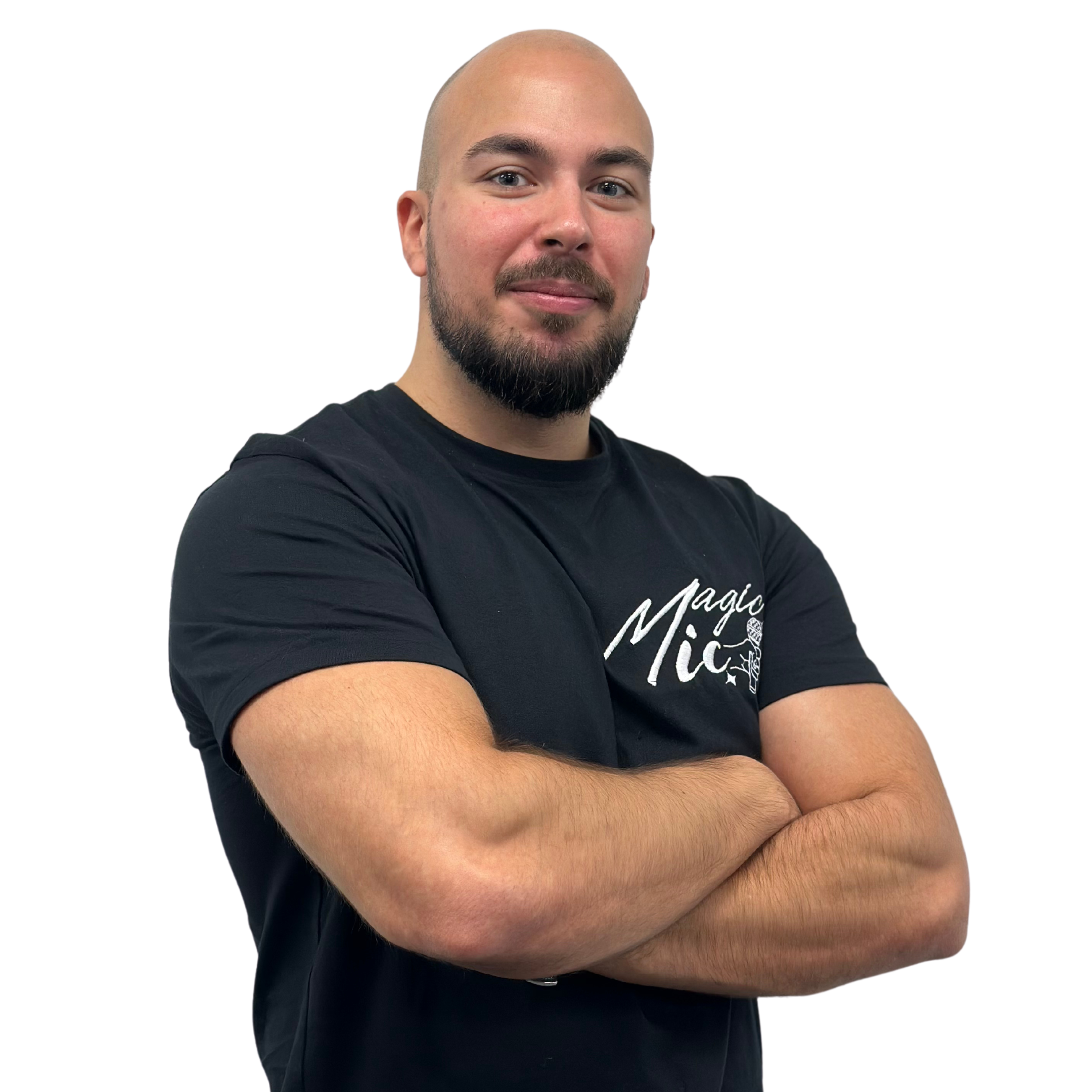 Person with a beard and crossed arms, wearing a black t-shirt, on a plain background.
