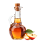 Glass bottle of apple cider vinegar with apple slices and leaves beside it.