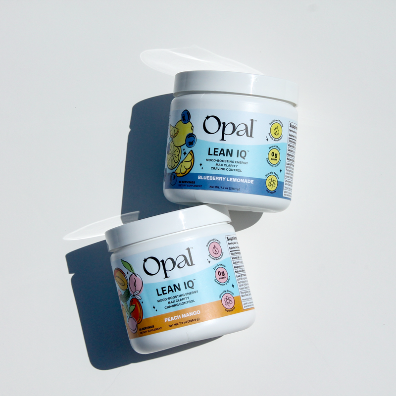Two white jars of Opal Lean IQ supplement, in Blueberry Lemonade and Peach Mango flavors, on a white surface.