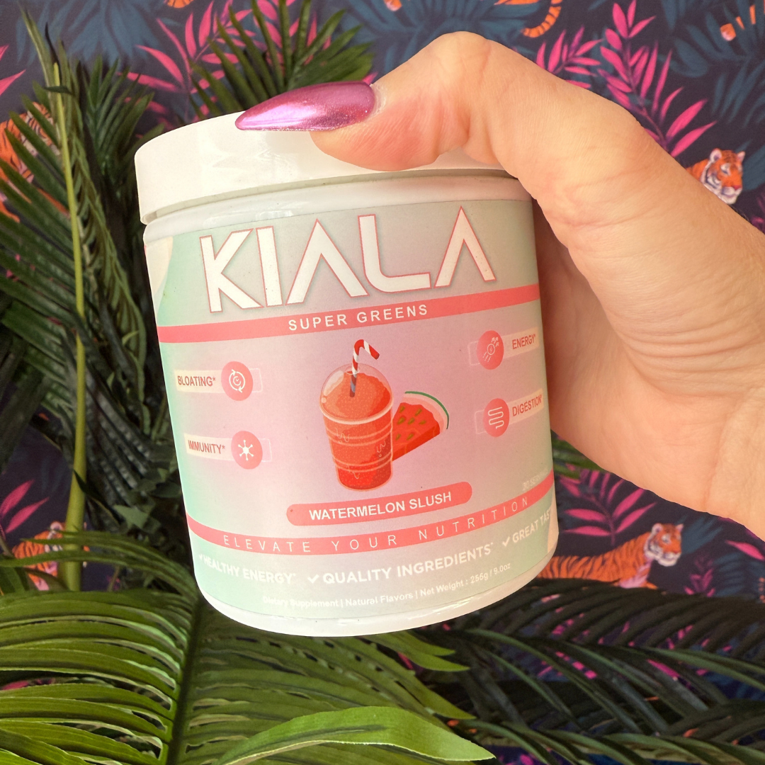 Hand holding a container of Kiala Super Greens with a watermelon design.