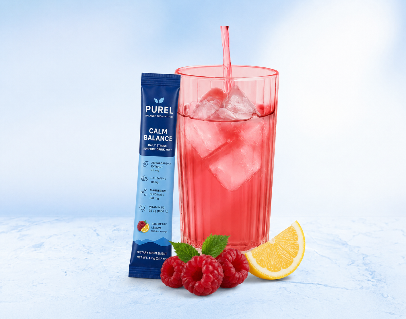 A PUREL Calm Balance drink mix packet next to a glass of red liquid, raspberries, and a lemon wedge.