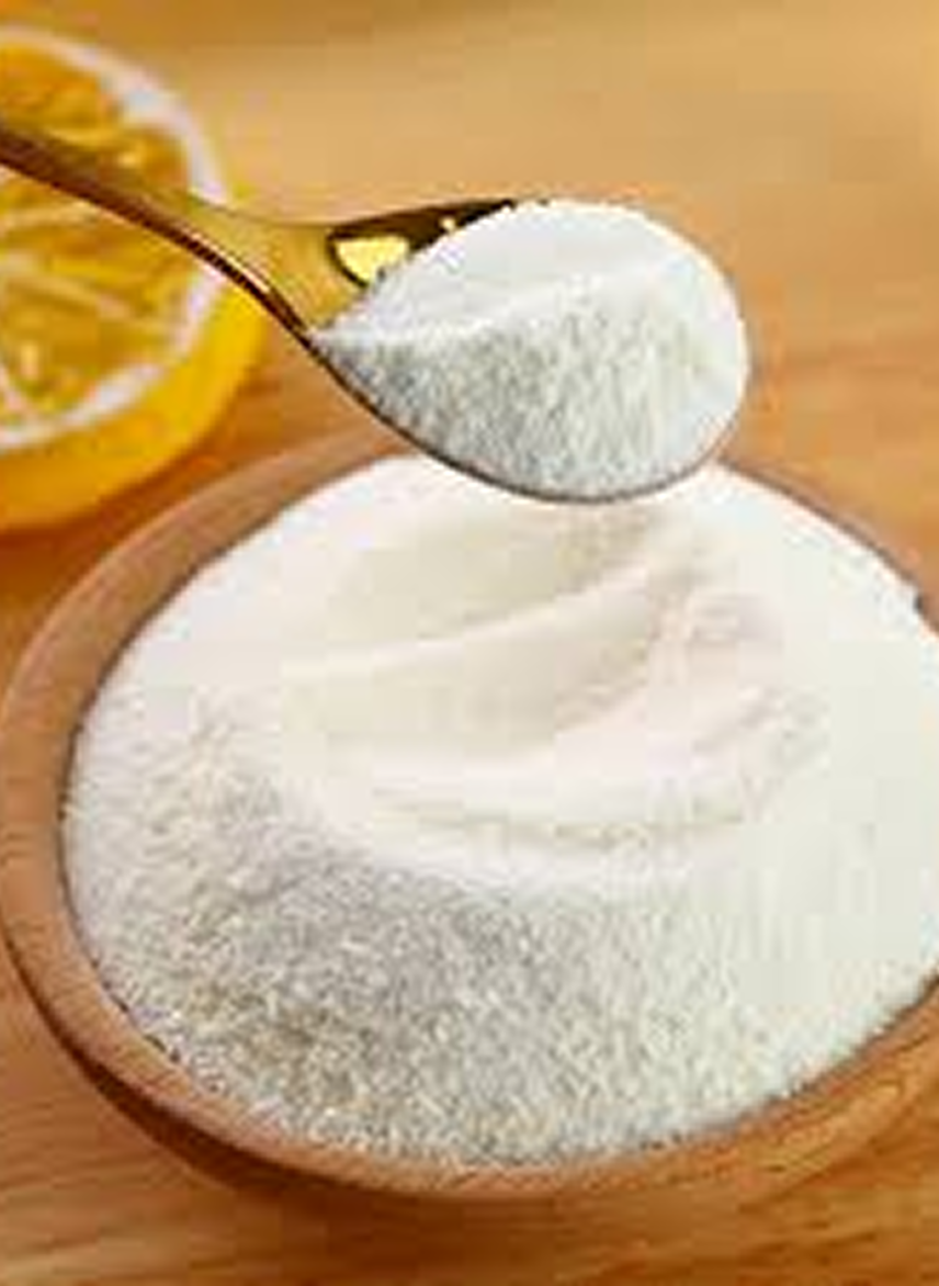 A spoon scooping white powder from a wooden bowl.