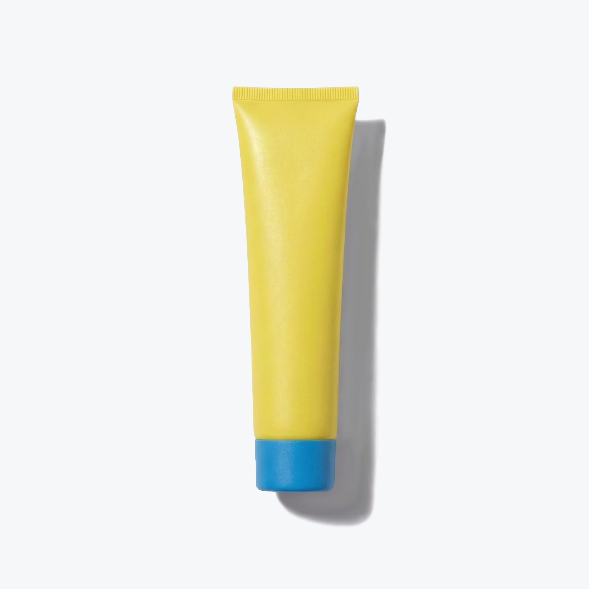 A yellow tube with a blue cap, shown from above on a white background with a shadow.