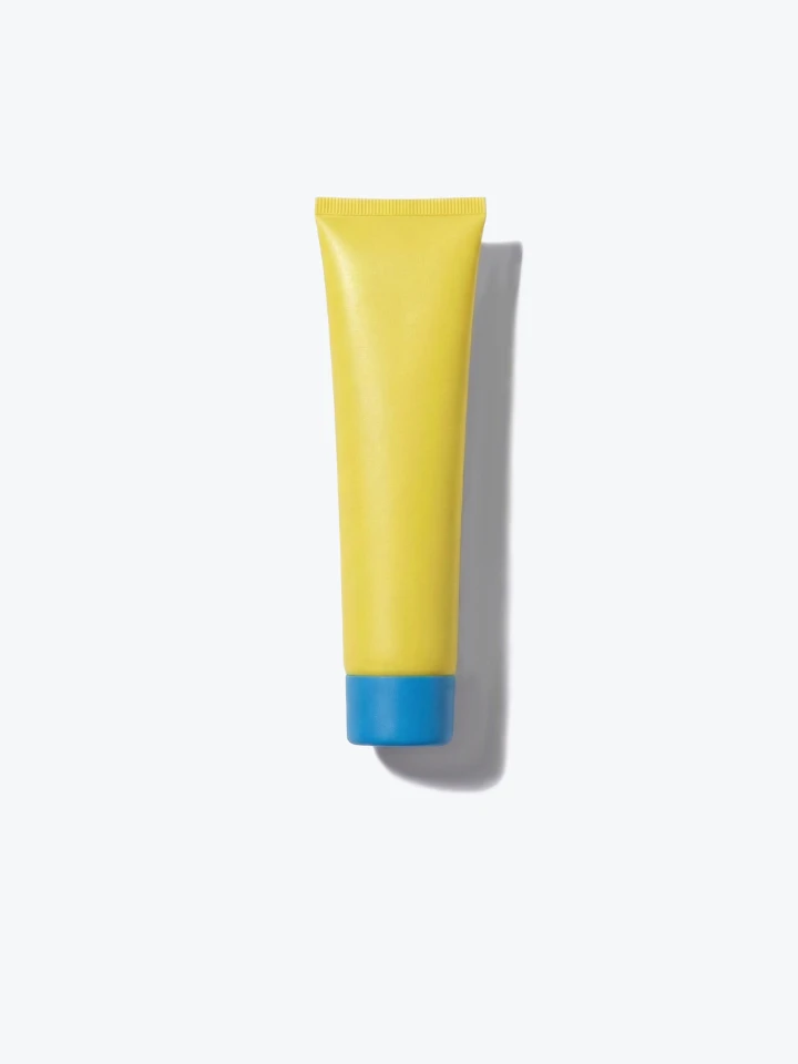 A yellow tube with a blue cap, shown from above on a white background with a shadow.