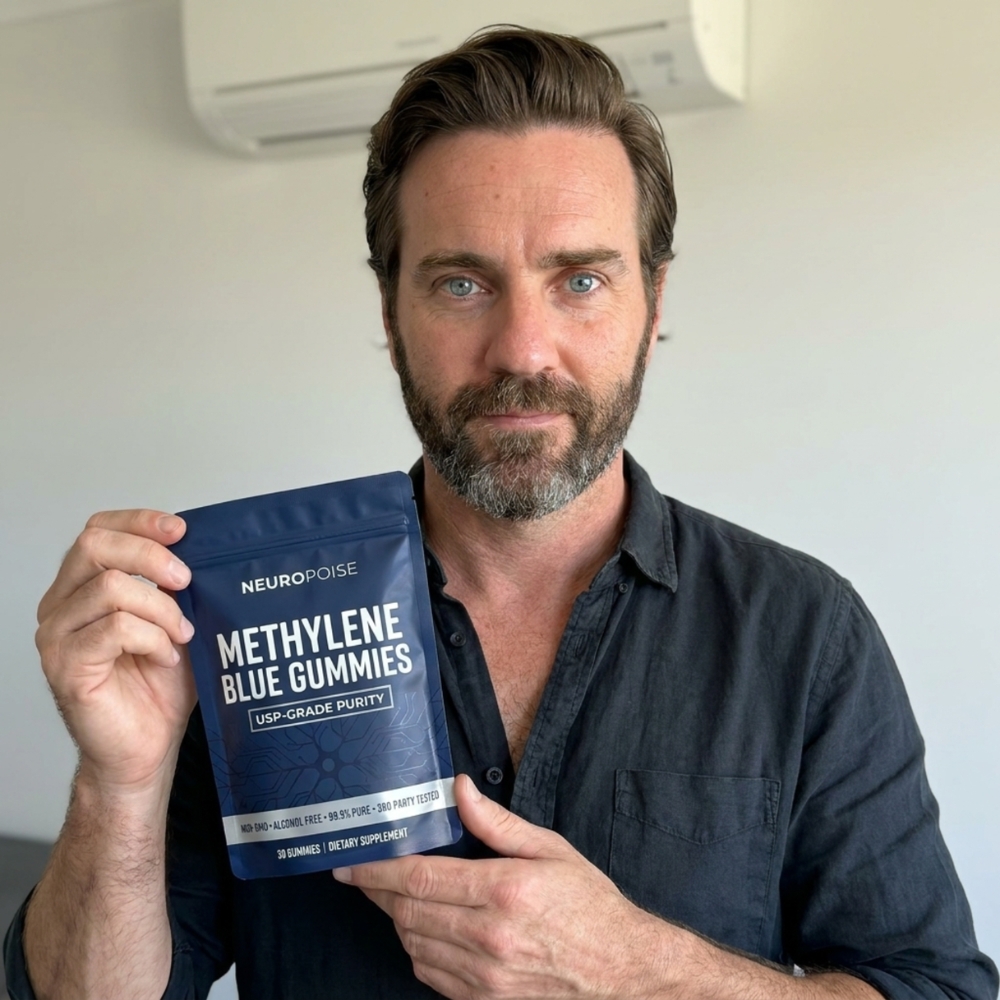 A man with a beard and blue eyes holds a blue pouch of Neuropoise Methylene Blue Gummies.