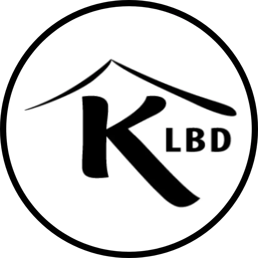 A circular logo with a stylized letter K under a roof shape, next to the letters LBD.