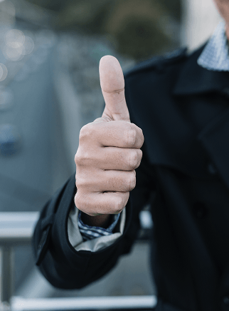 A close-up of a person's hand giving a thumbs-up sign.