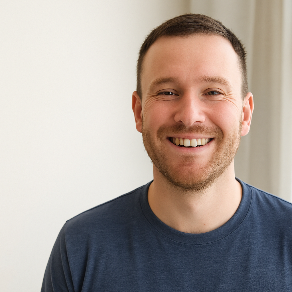 Smiling person in a blue shirt against a plain background.