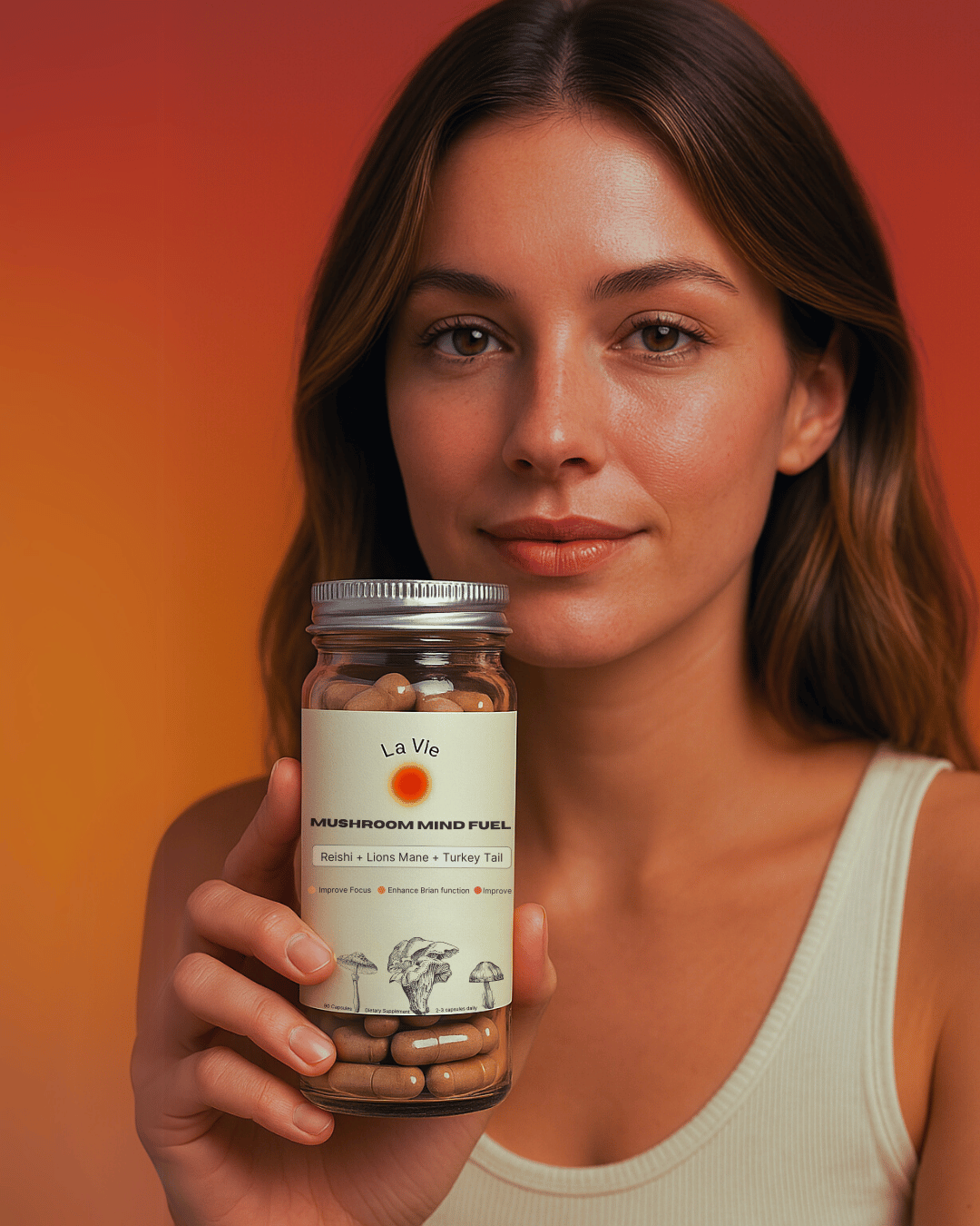 Person holding a jar of mushroom supplements against an orange background.