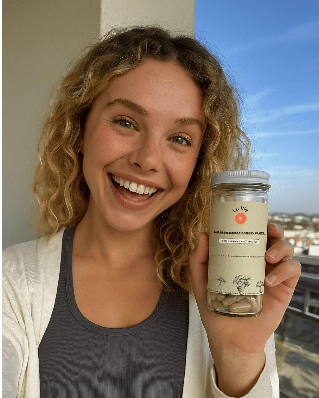 Person smiling and holding a jar labeled 'Mushroom Mind Fuel'.