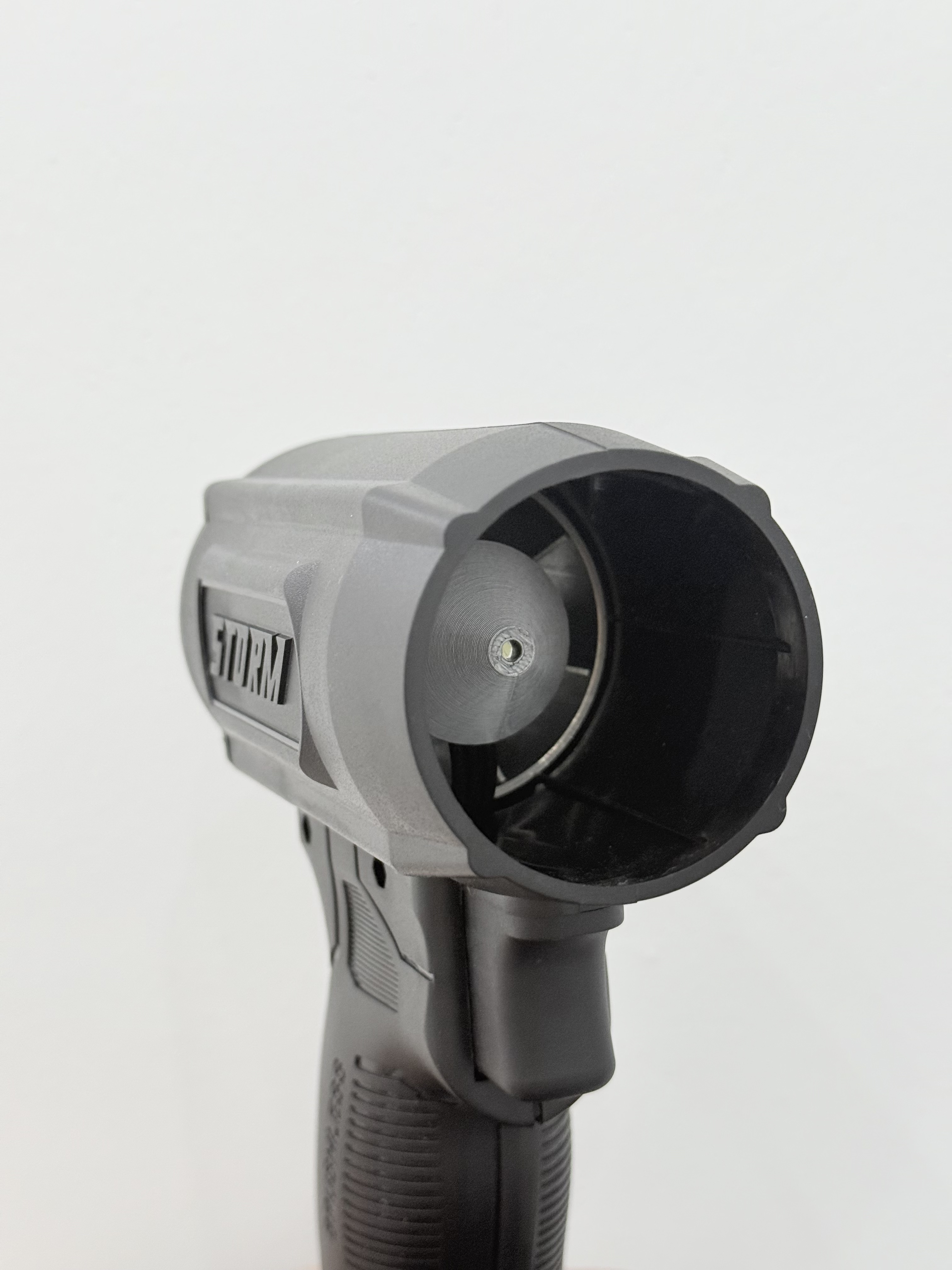 A close-up of a gray handheld blower with a pistol grip against a white background.