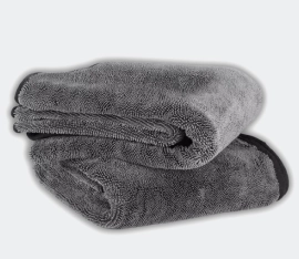 A folded, dark gray, plush microfiber towel on a light gray background.