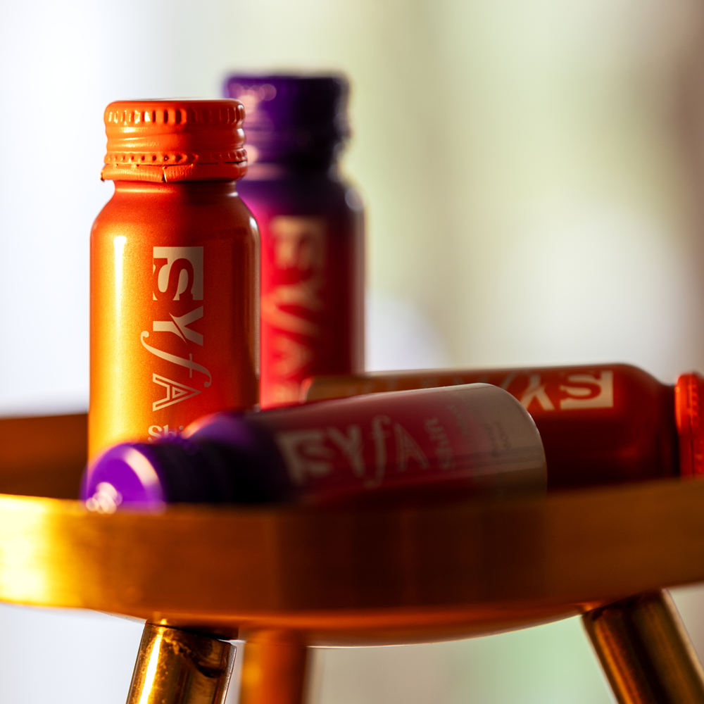 Colorful bottles on a wooden surface with blurred background.
