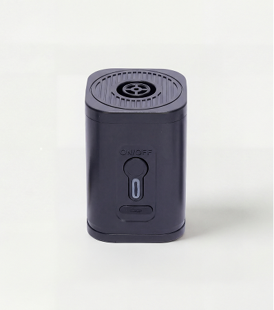 A close-up of a black, battery-operated pencil sharpener against a white background.