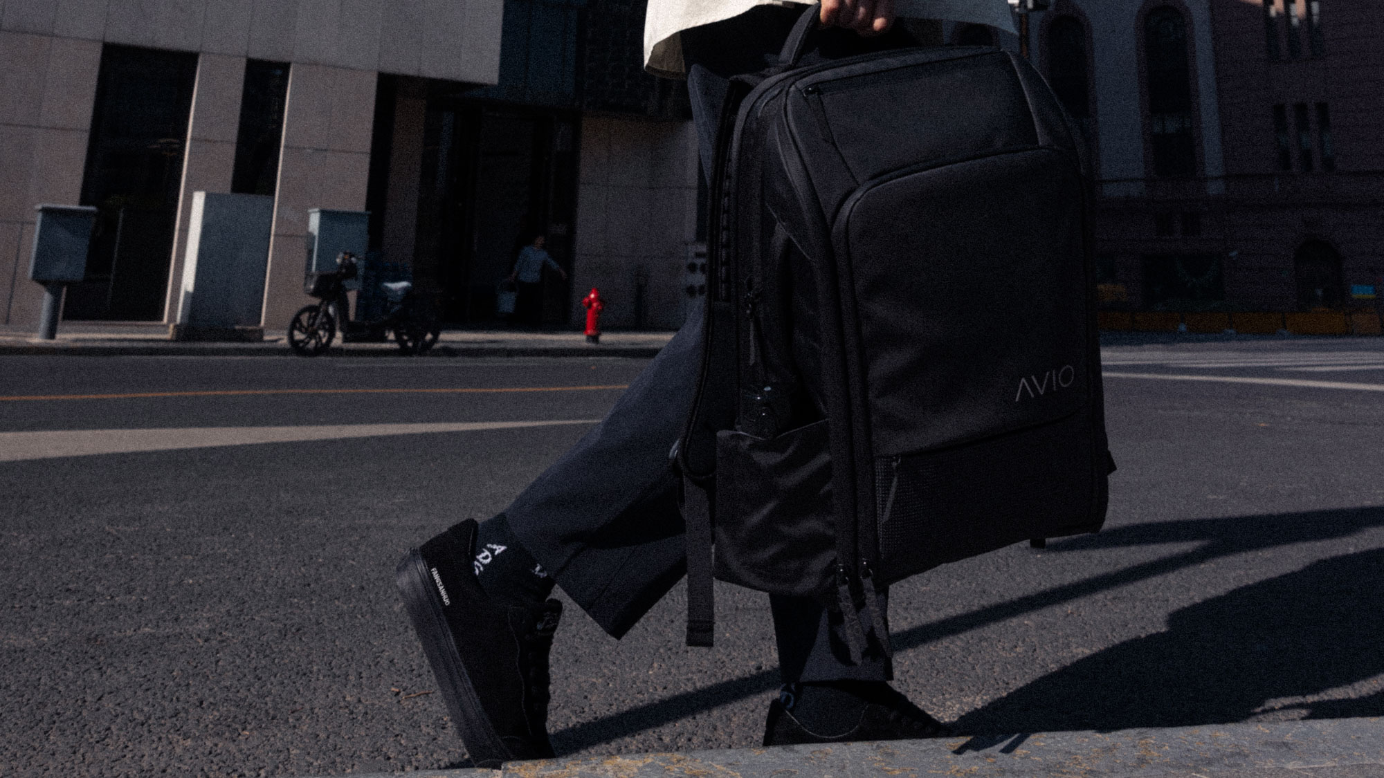 Person walking with a large black backpack on a city street.