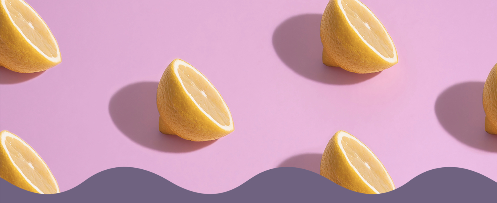 Halved lemons on a pink background with a wavy purple border.
