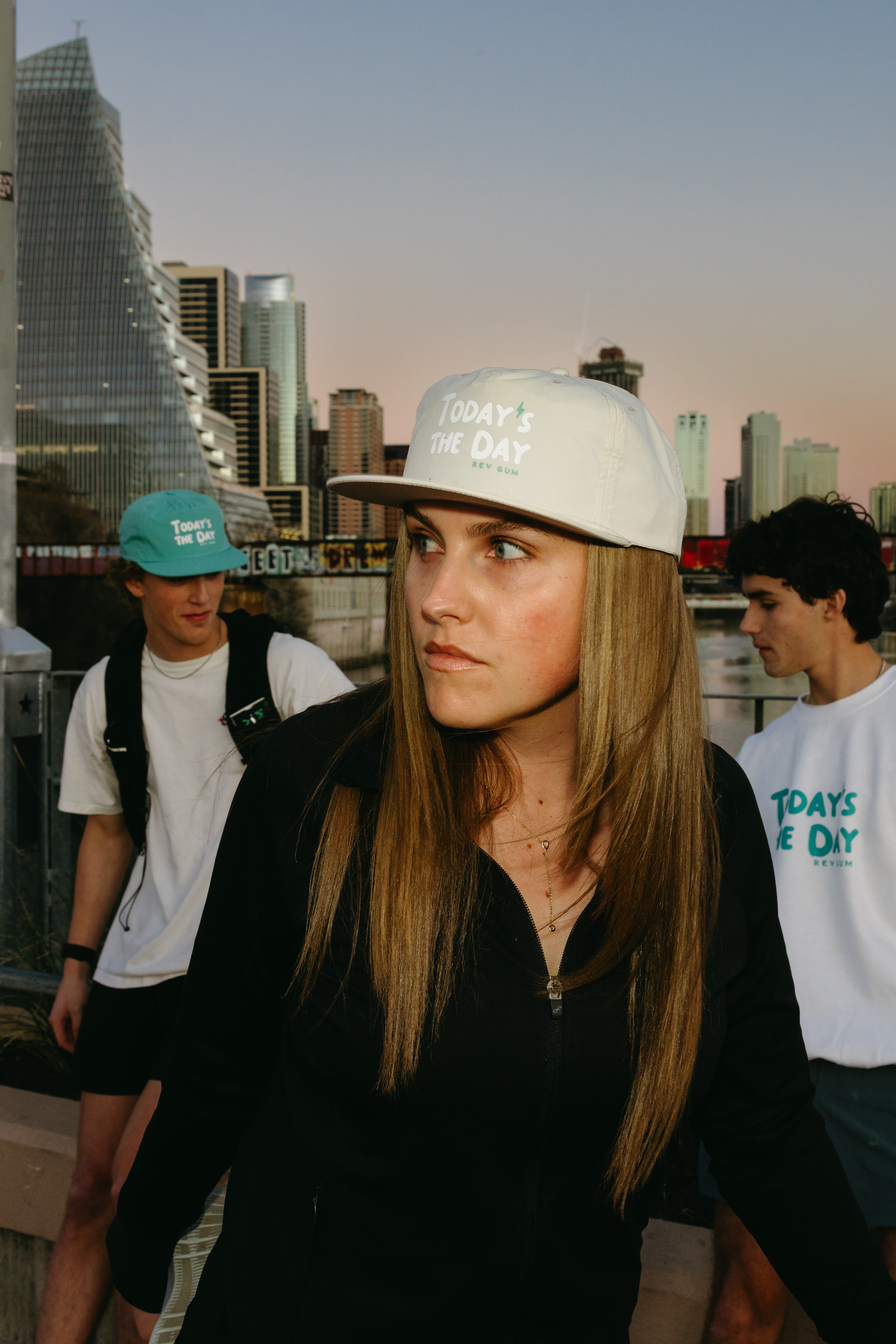 people in hats with  sunset cityscape in background