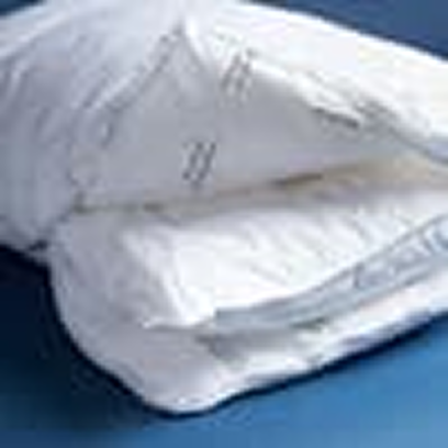 A fluffy white comforter folded in half on a blue surface.