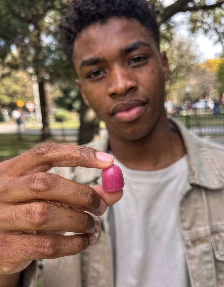 Kunde hält einzelne Kreatin Gummy in die Kamera – Geschmackstest im Park