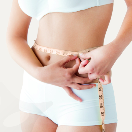 Person measuring waist with a tape measure.