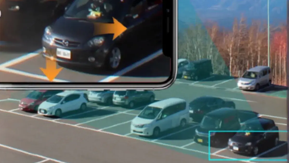 Image of a car in a parking lot with zoomed-in smartphone view.