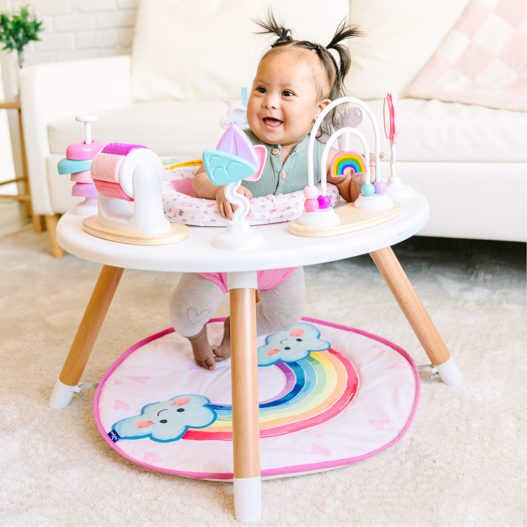 Baby in a play activity center with colorful toys attached.