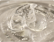 Close-up of clear, glossy gel swirling in a container.