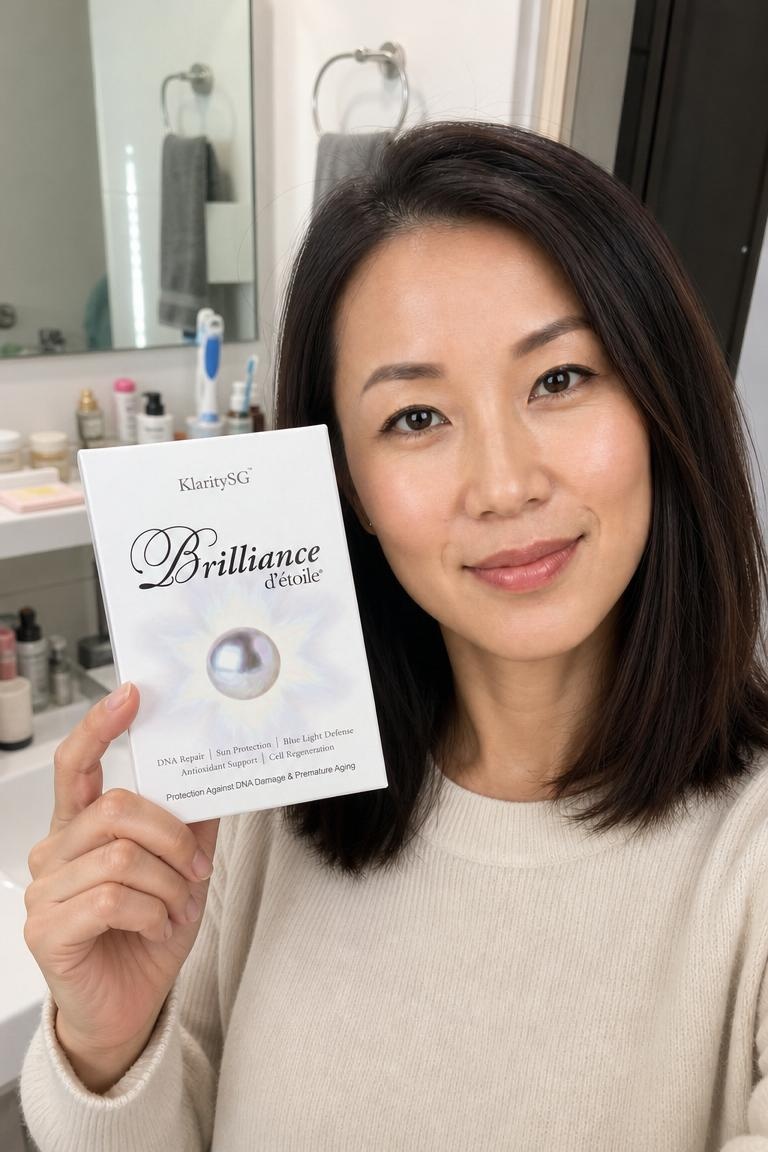 A woman in a bathroom holds a white box labeled 'KlaritySG Brilliance d'étoile.'