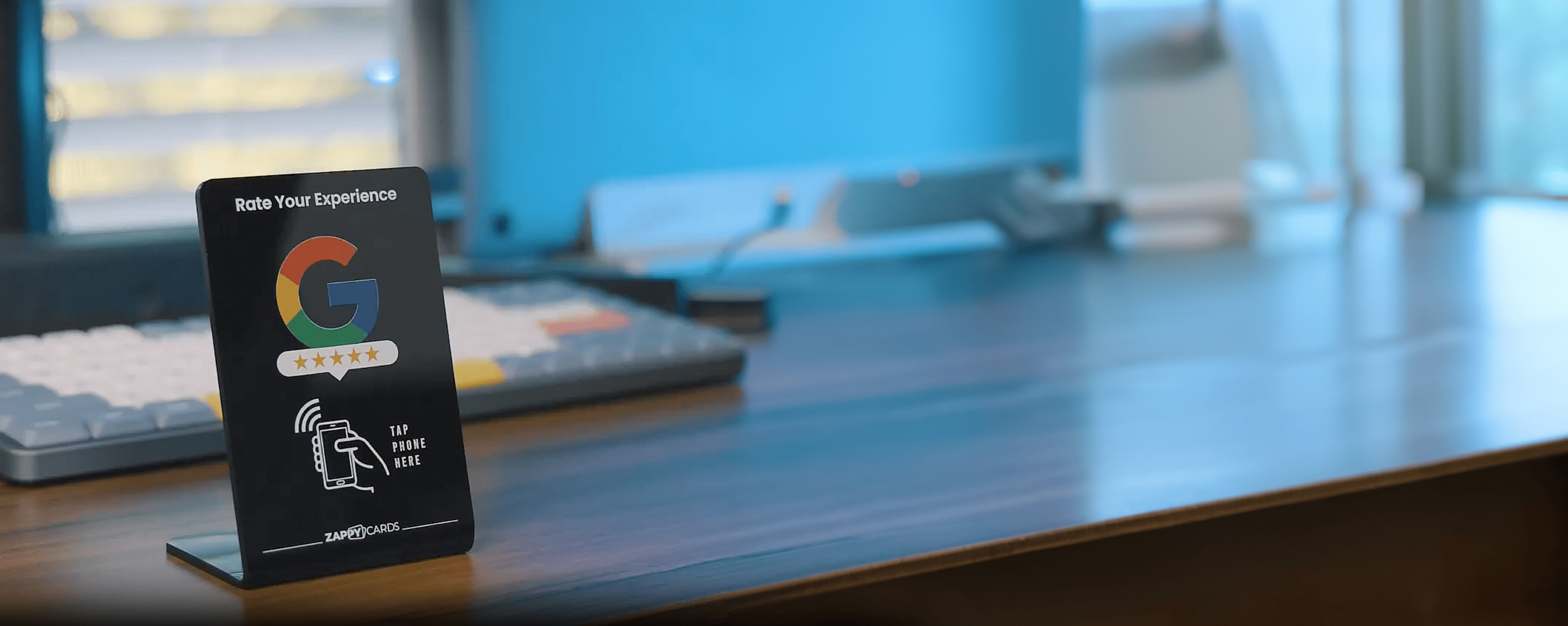 A desk with a sign prompting to rate experience using a phone tap.