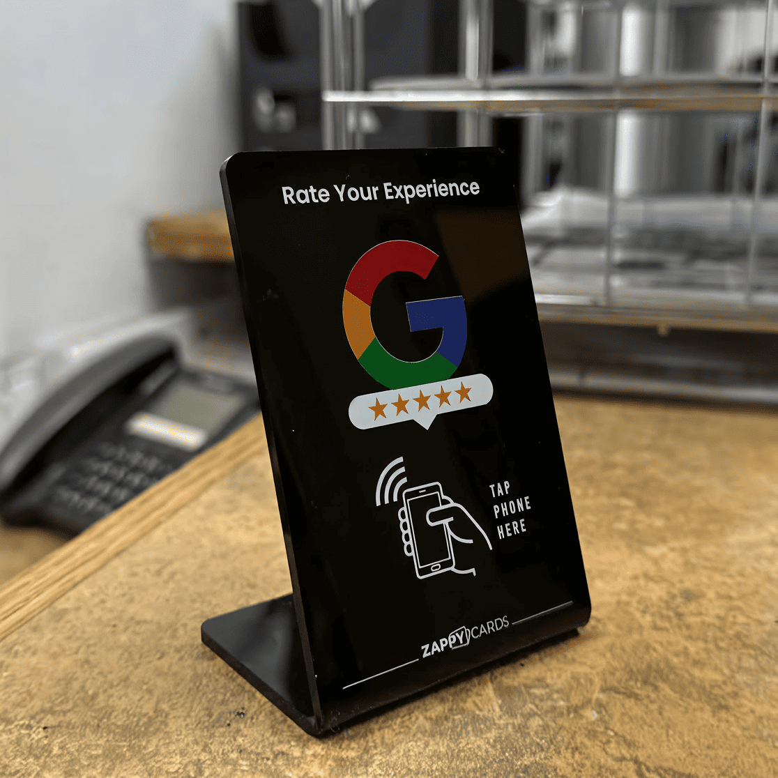 Black stand with Google logo, stars, and 'Rate Your Experience' text on a counter.