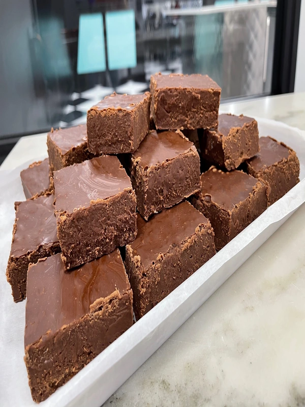A tray of stacked chocolate fudge squares on a countertop.