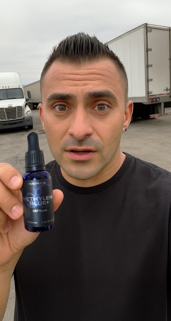 Person holding a bottle of Methylene Blue near trucks.