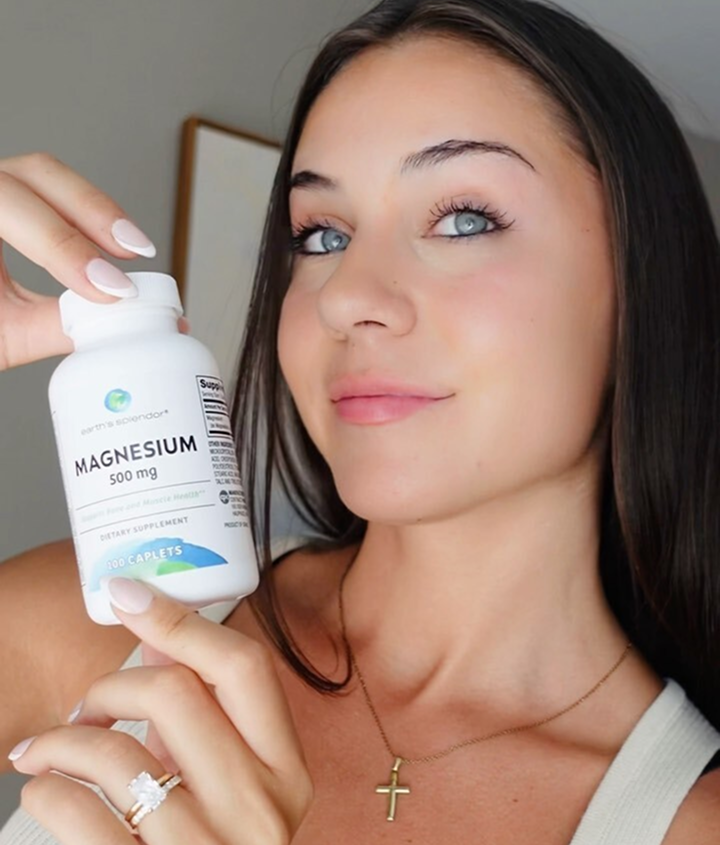Person holding a bottle of magnesium supplement.
