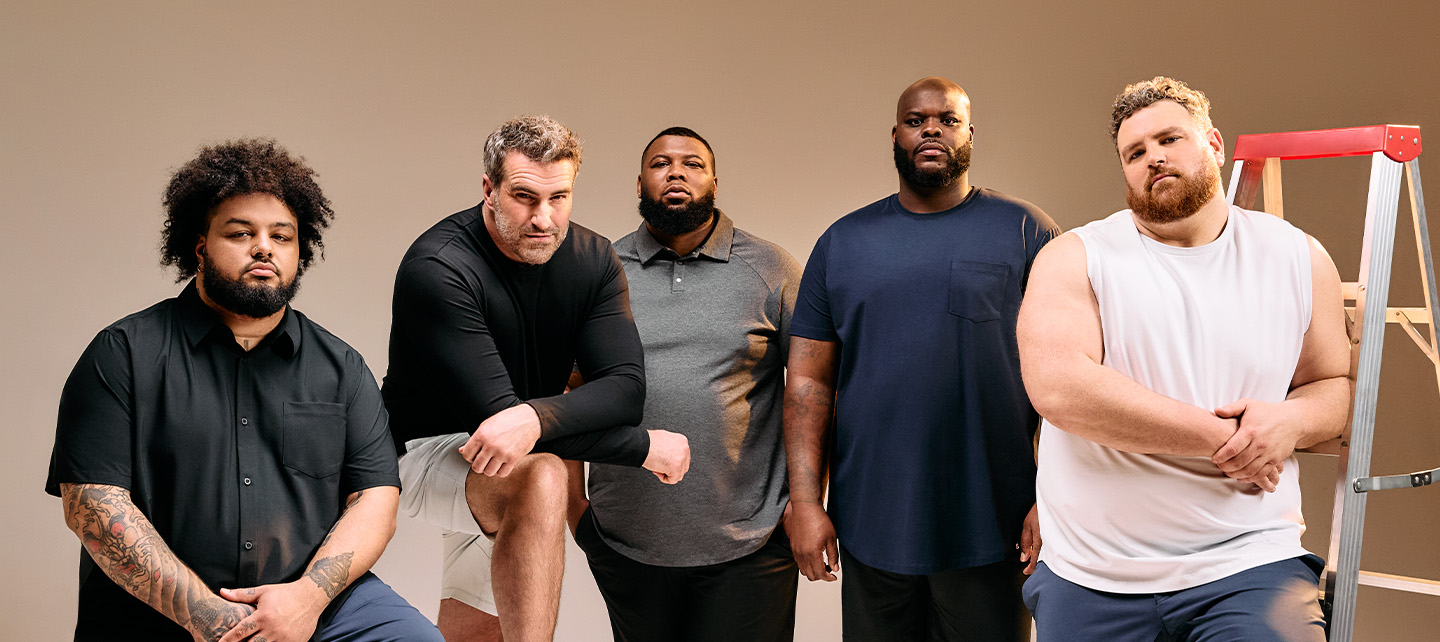 A group of five diverse, large-build men posing in casual clothing against a neutral background.