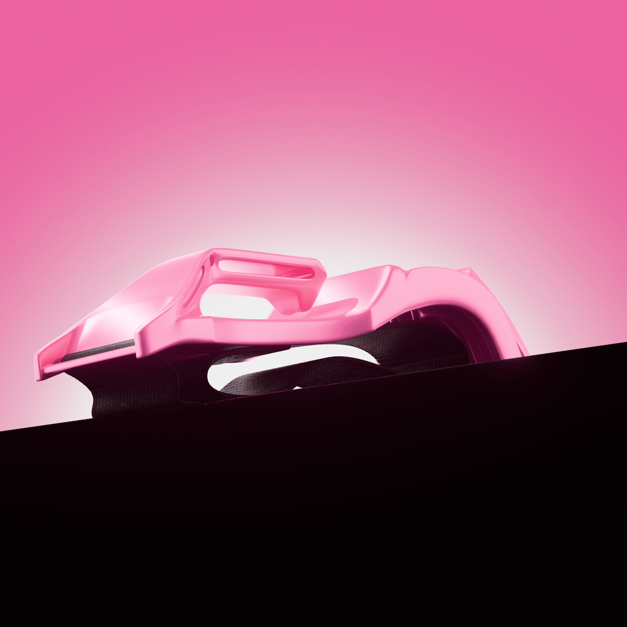 A close-up side view of a glossy pink snowboard binding against a pink gradient background.