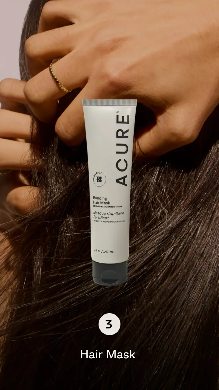 Person running their hands through their hair with product in the foreground. Step 3 hair mask.