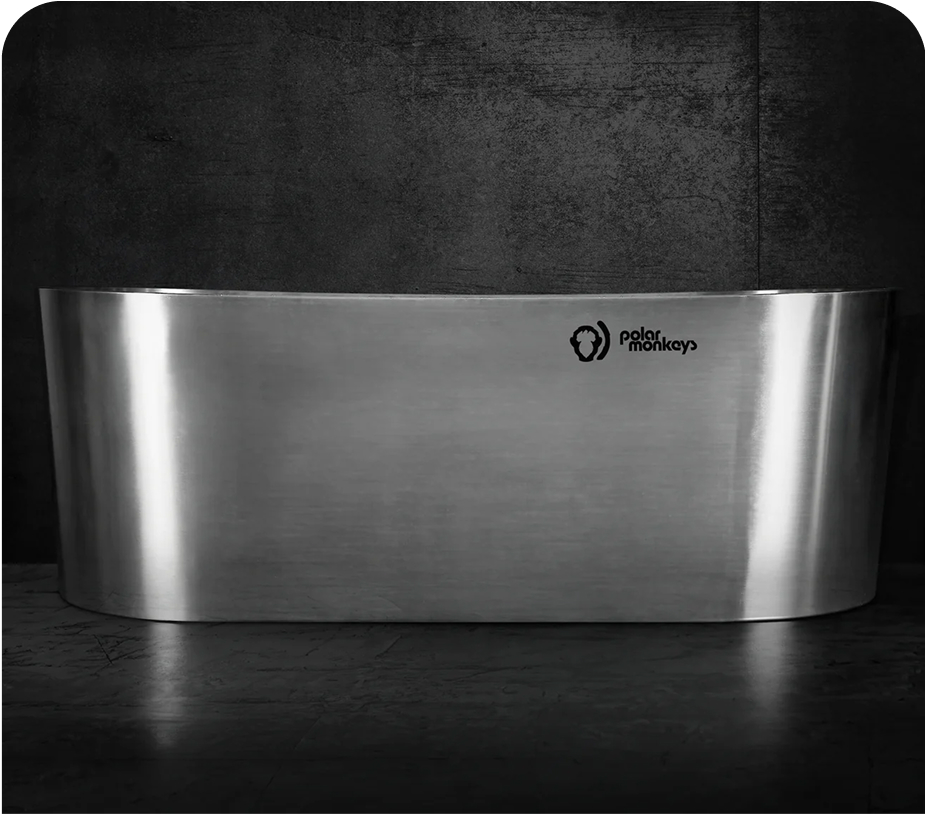 Stainless steel freestanding bathtub by Polar Monkeys against a dark background.